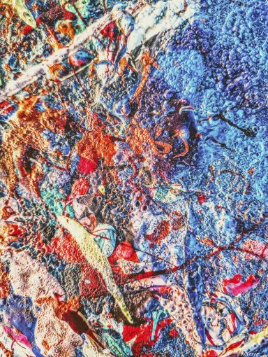 Colorful abstract pattern with swirling textures in blue, orange, and red hues.